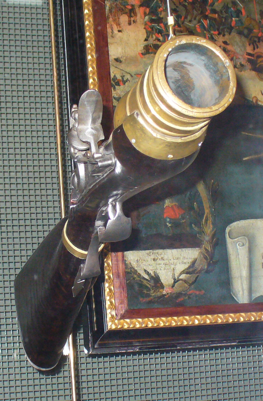 Figure 2 — A Russian bombardier hand mortar of the first quarter of the eighteenth century, hung muzzle-up in a case at the State Historical Museum in Moscow: a flintlock on a dark walnut stock, with a brass …