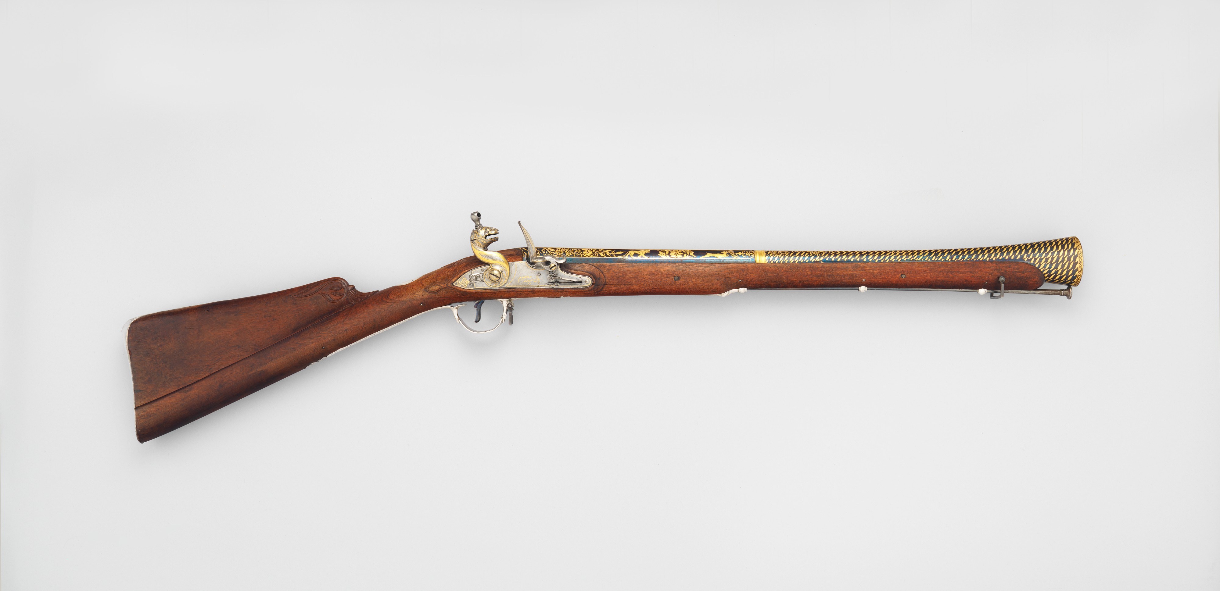 Figure 2 — A flintlock blunderbuss with a brass flared, trumpet-shaped muzzle and an ornate animal-head cock. Short, large-bored, and loaded with a scatter of shot, the blunderbuss was ideal for the confined …