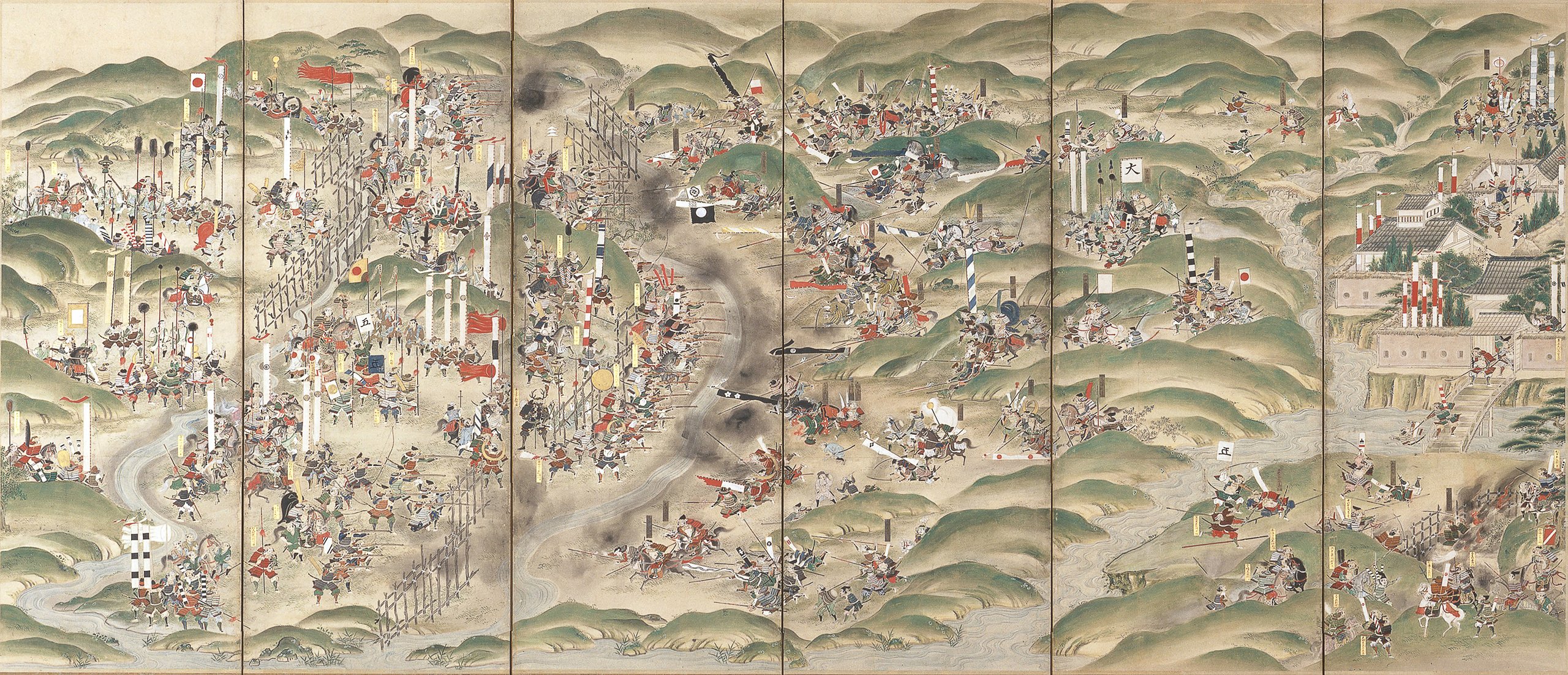Figure 2 — A Japanese folding-screen painting of the Battle of Nagashino, 1575: ranks of ashigaru gunners fire their tanegashima matchlocks from behind a wooden palisade into the charging Takeda cavalry. Sour…