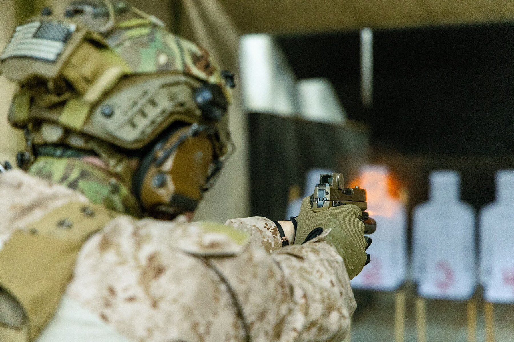 Figure 3 — A Marine firing an M18 with a red dot on the slide - the conventional arrangement, in which the optic rides the slide through every shot. The pistol documented here does the opposite.