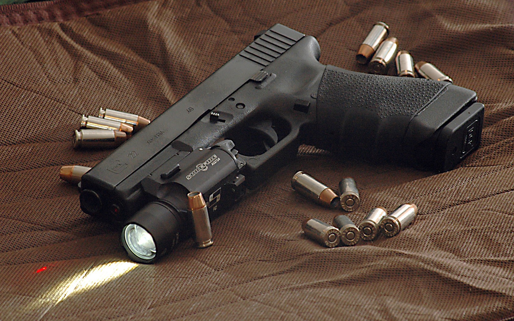 Figure 7 — A Glock 22, the full-size .40 S&W Glock, shown with .40 cartridges and a mounted weapon light. The Glock 22 and the compact Glock 23 were, in the usual account, the first pistols on the market for …
