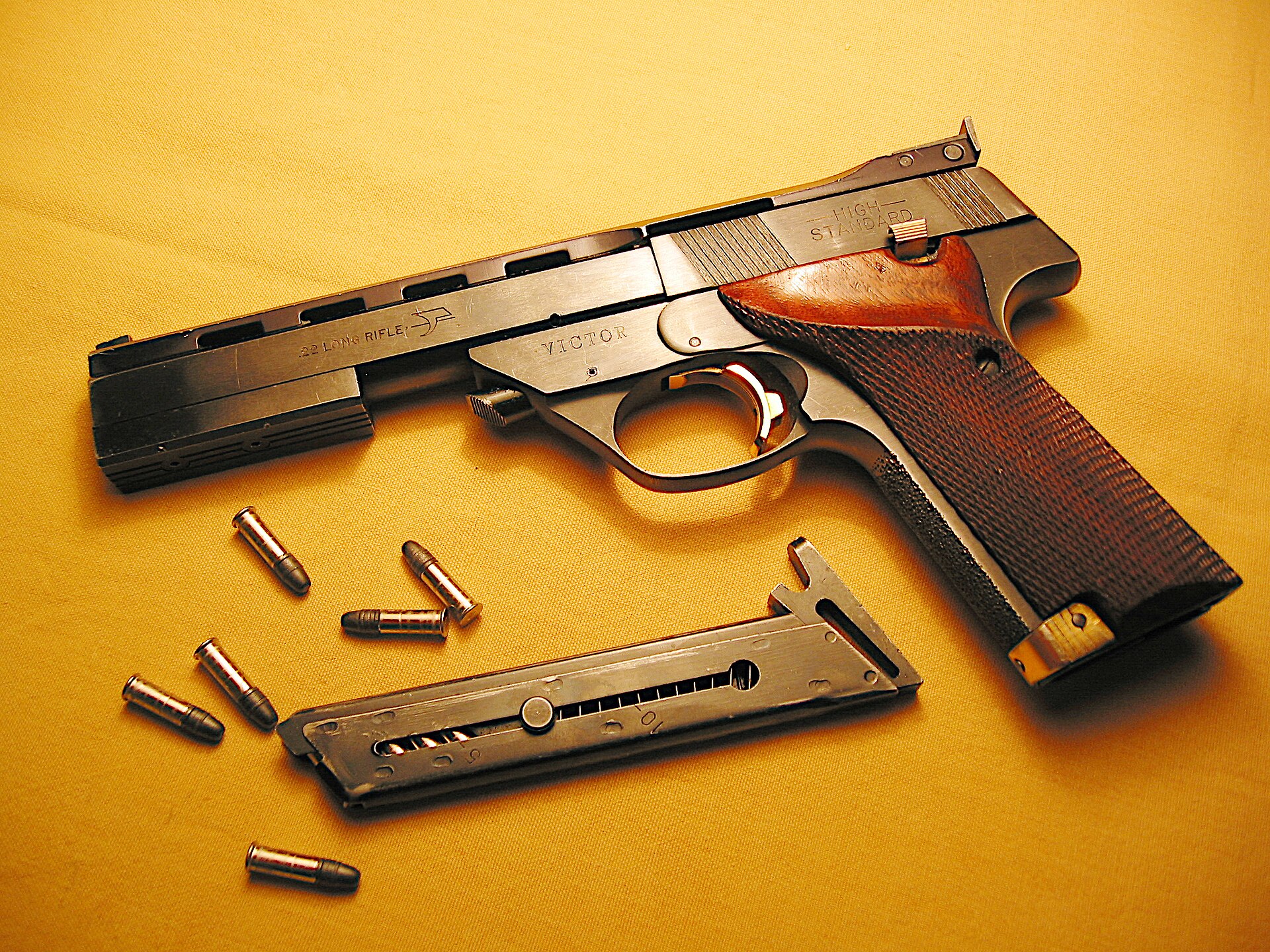 Figure 1 — A High Standard Victor, identified by the VICTOR marking on the frame, with its magazine. As photographed, the ventilated rib runs back from the barrel over the slide and carries the rear sight at …