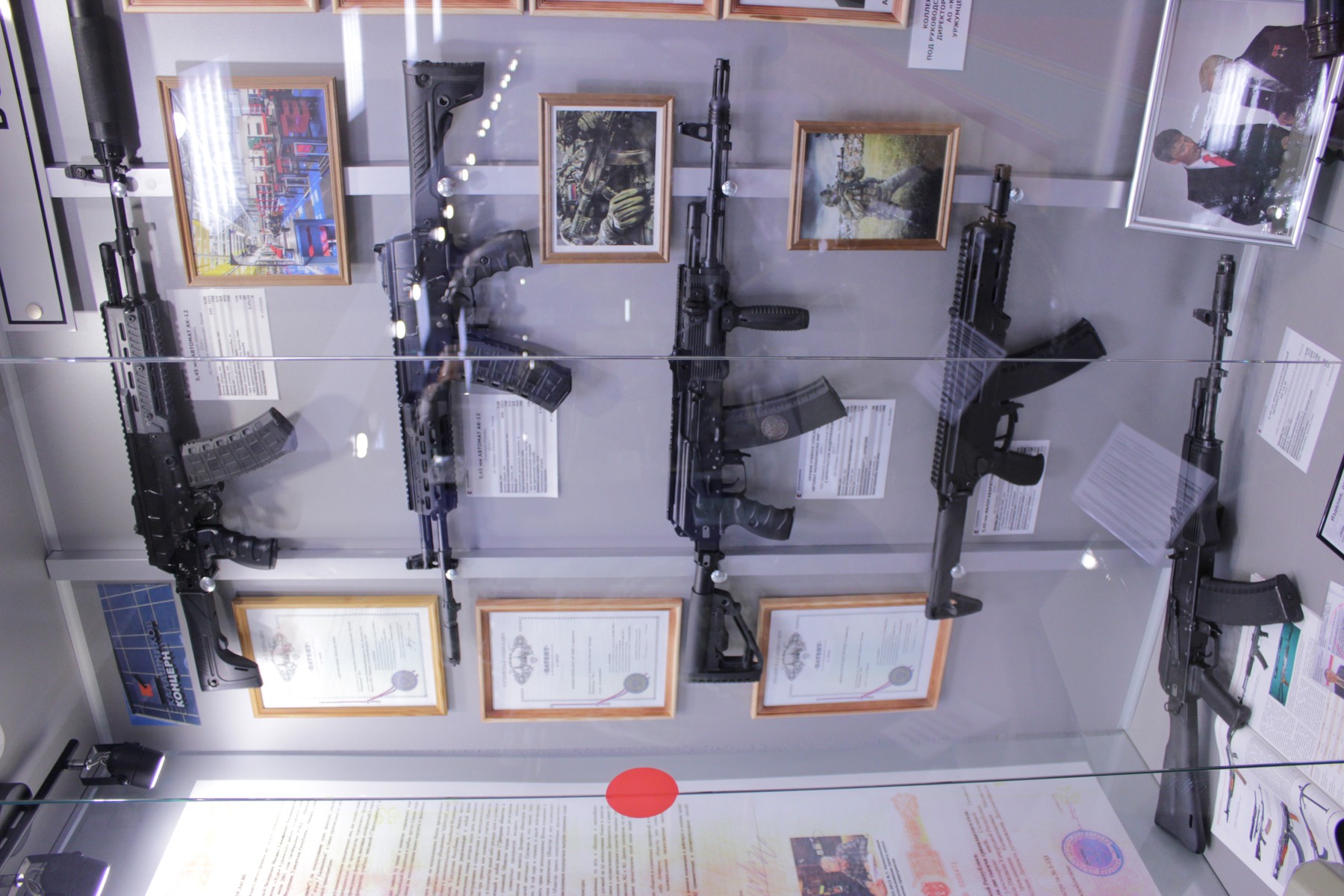 Figure 4 — A wall of Kalashnikov variants at the Izhmash museum. The manufacturing changes that separate these rifles are far more consequential than the visual ones.