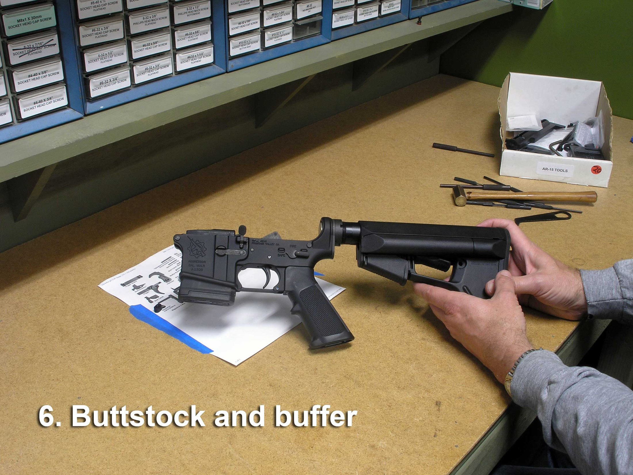 Figure 4 — Installing the receiver extension and buffer assembly. The buffer retainer and its spring live under the front of the tube, and this is the step that most reliably launches a small part across a wo…