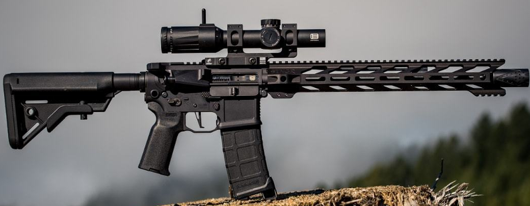 Figure 5 — A free-float M-LOK handguard on an AR-15 carrying a magnified optic. The handguard surrounds the barrel without touching it; the only joint is at the receiver.