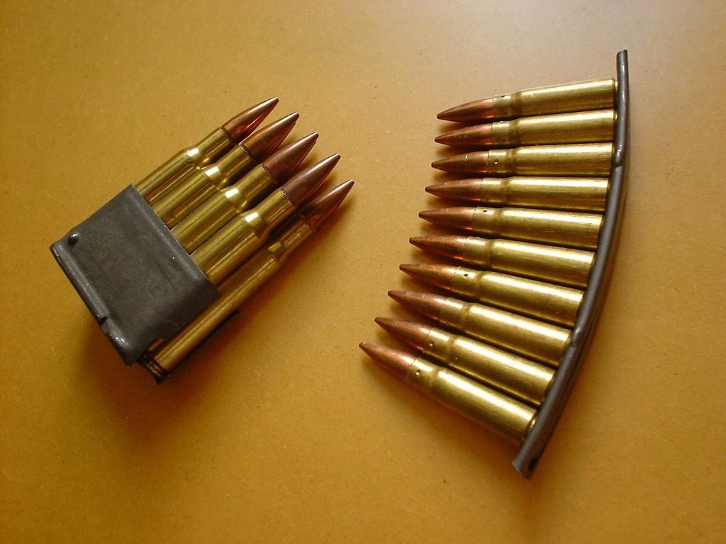 Figure 5 — An M1 en-bloc clip beside an SKS stripper clip. A stripper clip is only a loading tool: you push the rounds off it and keep it. The en-bloc clip is part of the feed system: it goes in with the ammu…