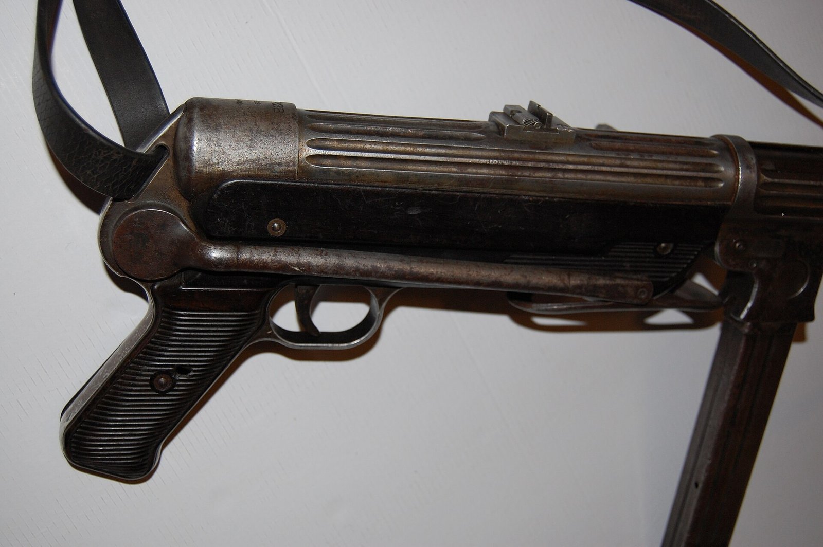 Figure 5 — The MP 38's machined receiver. The deep longitudinal flutes cut along the tube are the identifying feature, and they exist because the receiver started as a solid piece of steel and had metal remov…