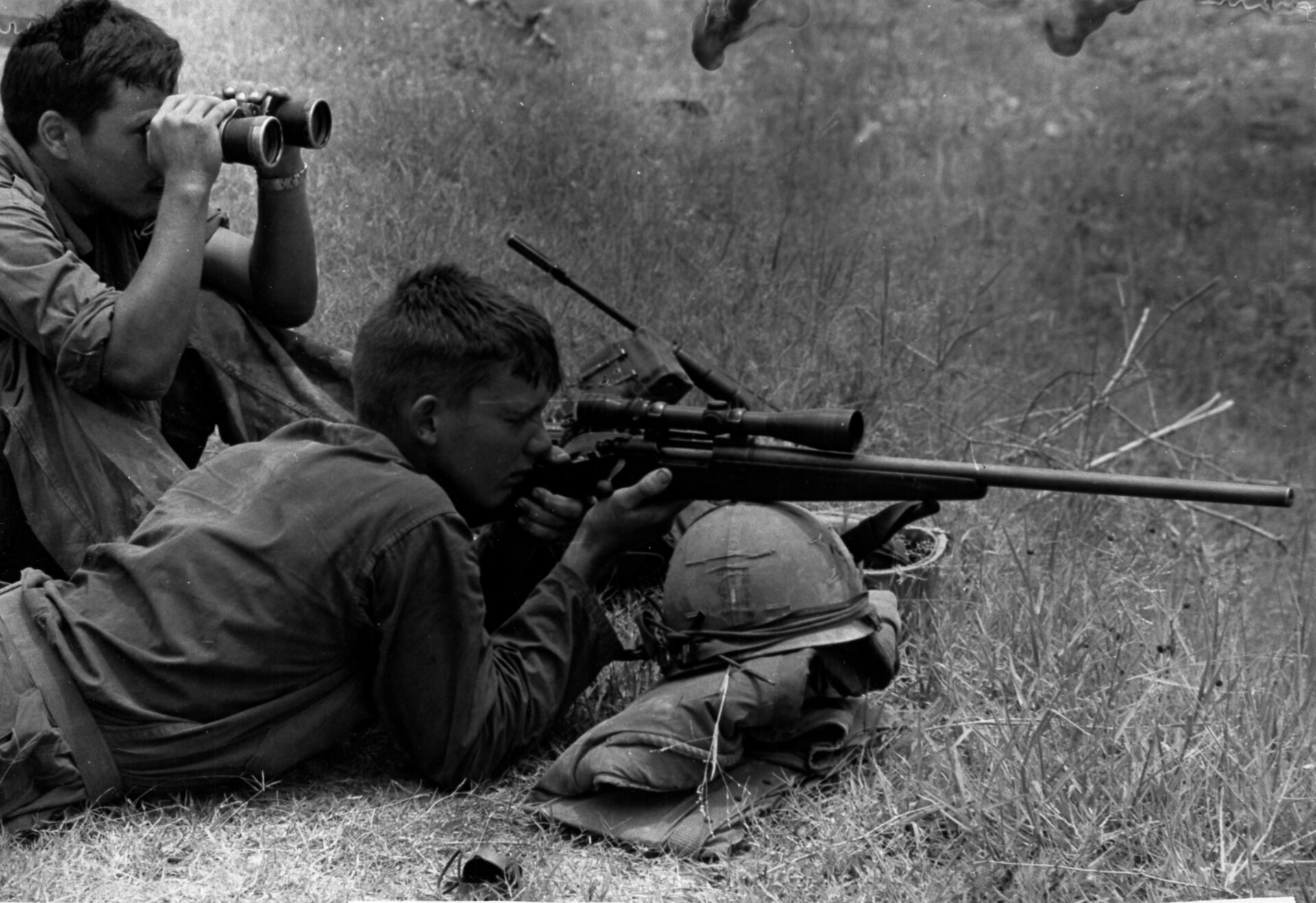 Figure 3 — A 7th Marines sniper with a scoped Remington 700 during Operation Mameluke Thrust, 18 July 1968, with his observer on binoculars beside him. The caption of record calls it a "Remington 700 sniper r…