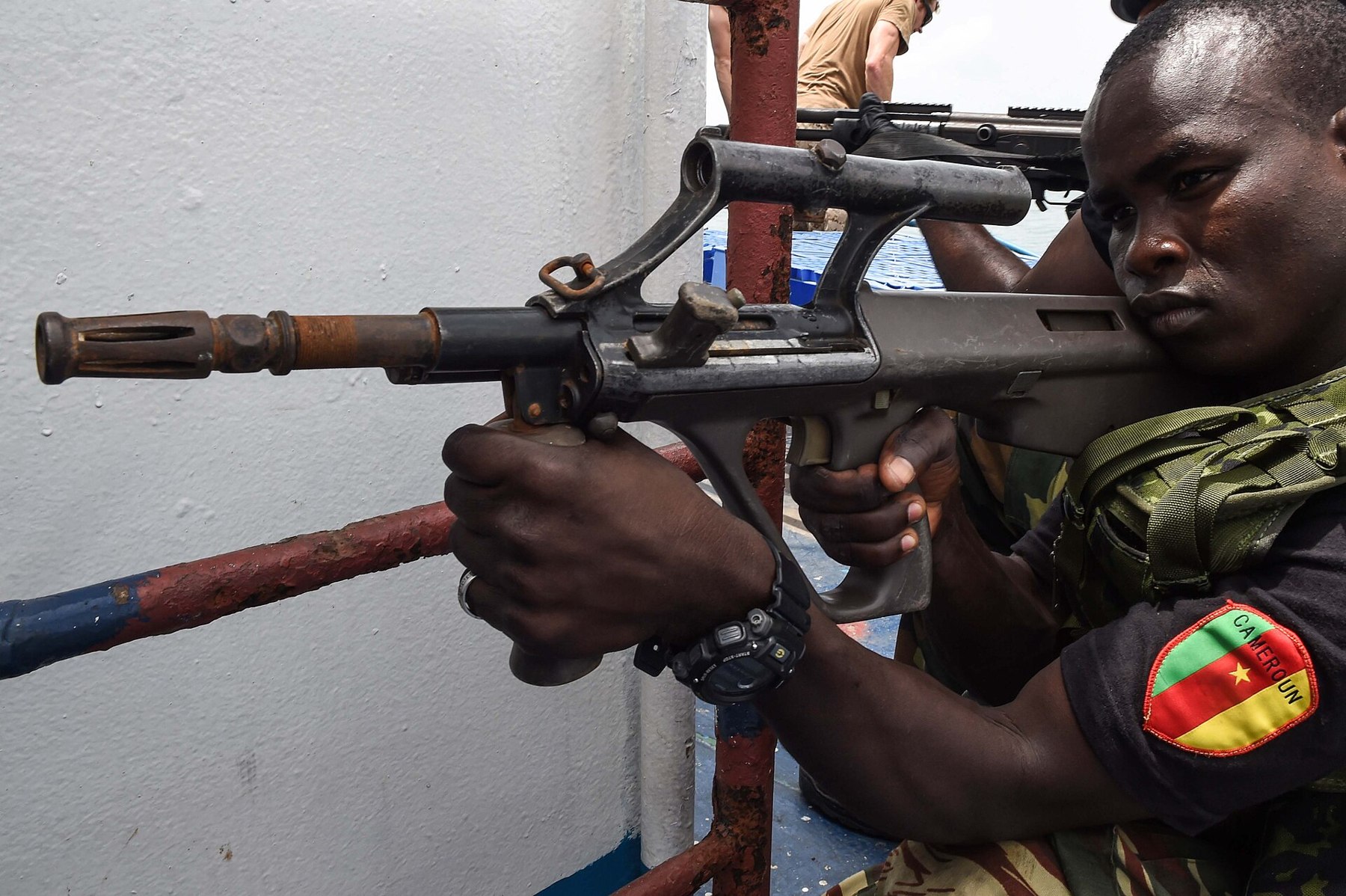 Figure 3 — A member of Cameroon's rapid-response brigade with an AUG A1 during exercise Obangame Express at Douala in 2017. The integral optic, the non-reciprocating cocking handle on the left of the receiver…