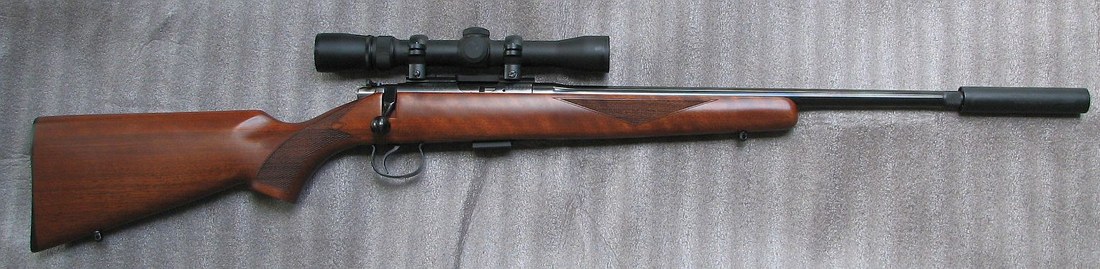 Figure 4 — A scoped rimfire bolt rifle wearing a can. On a full-length rifle barrel the powder is essentially spent before the gas reaches the suppressor, which is why first-round pop is mild here and pronoun…