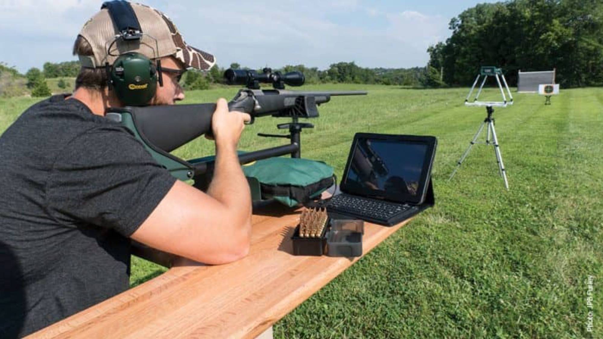 Figure 4 — A chronograph in use: the two skyscreens stand on a tripod a short distance downrange, and the projectile is timed between them as it passes. This is how every velocity figure in this volume was ar…