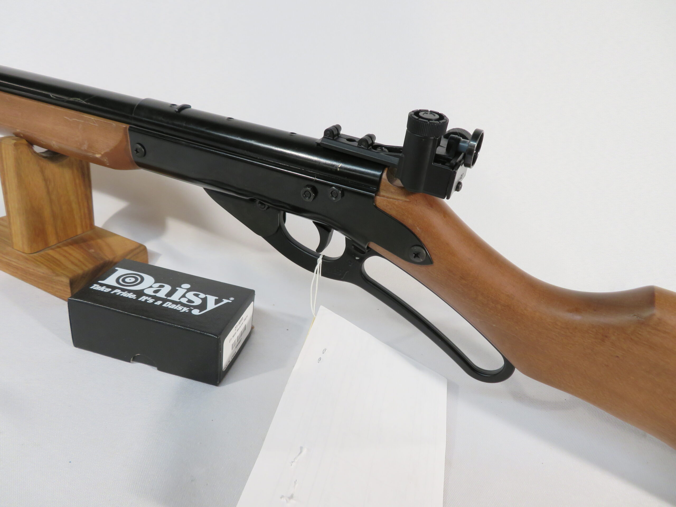Figure 4 — The receiver and sight package of a Daisy Avanti 499B Champion: a click-adjustable aperture rear sight standing well above the barrel, a hardwood target stock, and the lever loop of the Red Ryder p…