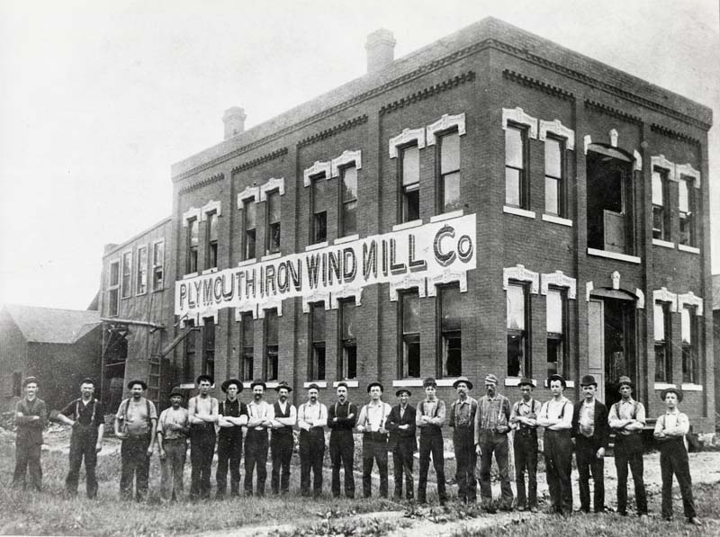 Figure 4 — The Plymouth Iron Windmill Company works, its name painted across a banner on the second storey, with what appears to be most of the workforce lined up in front. Two dozen men is the scale of the e…