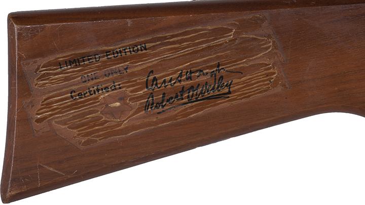 Figure 7 — The stock of the same gun, stamped "LIMITED EDITION / ONE ONLY / Certified:" over the signatures of Cass Hough and Robert Wesley, with the gold star imprint now ghosted from handling. The wear matt…