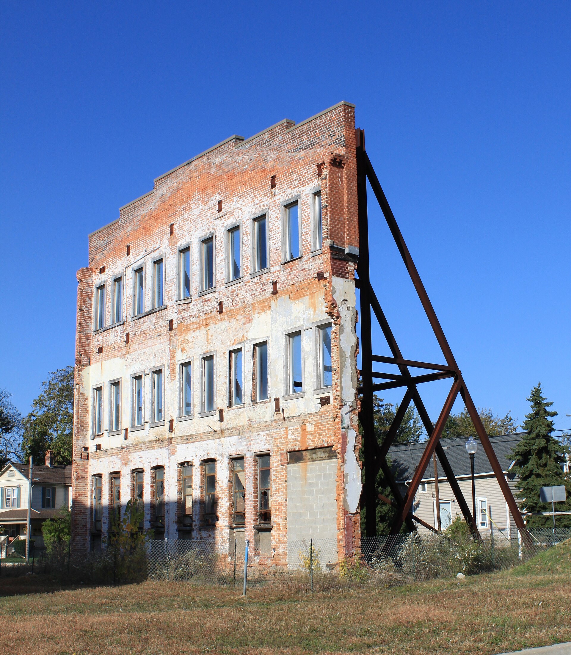 Figure 5 — What was left standing in Plymouth, Michigan: a surviving wall of the former Daisy factory on Union Street, awaiting the redevelopment that became Daisy Square. Seventy-six years of the company's l…