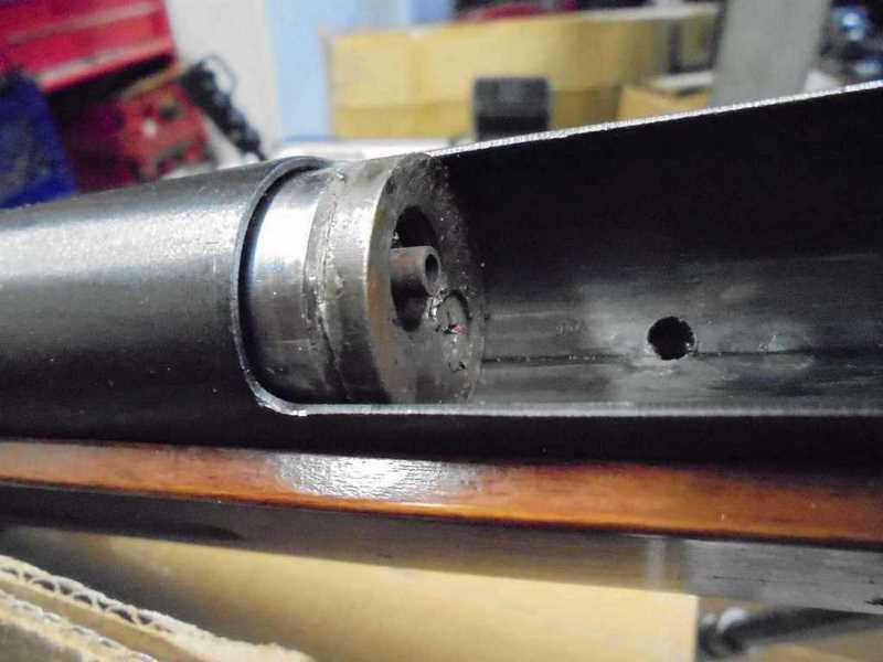 Figure 6 — The loading port open, looking down into the breech. The bright ring is the movable breech assembly, withdrawn from the barrel; the small central bore is the mouth the round seats into, and the pas…