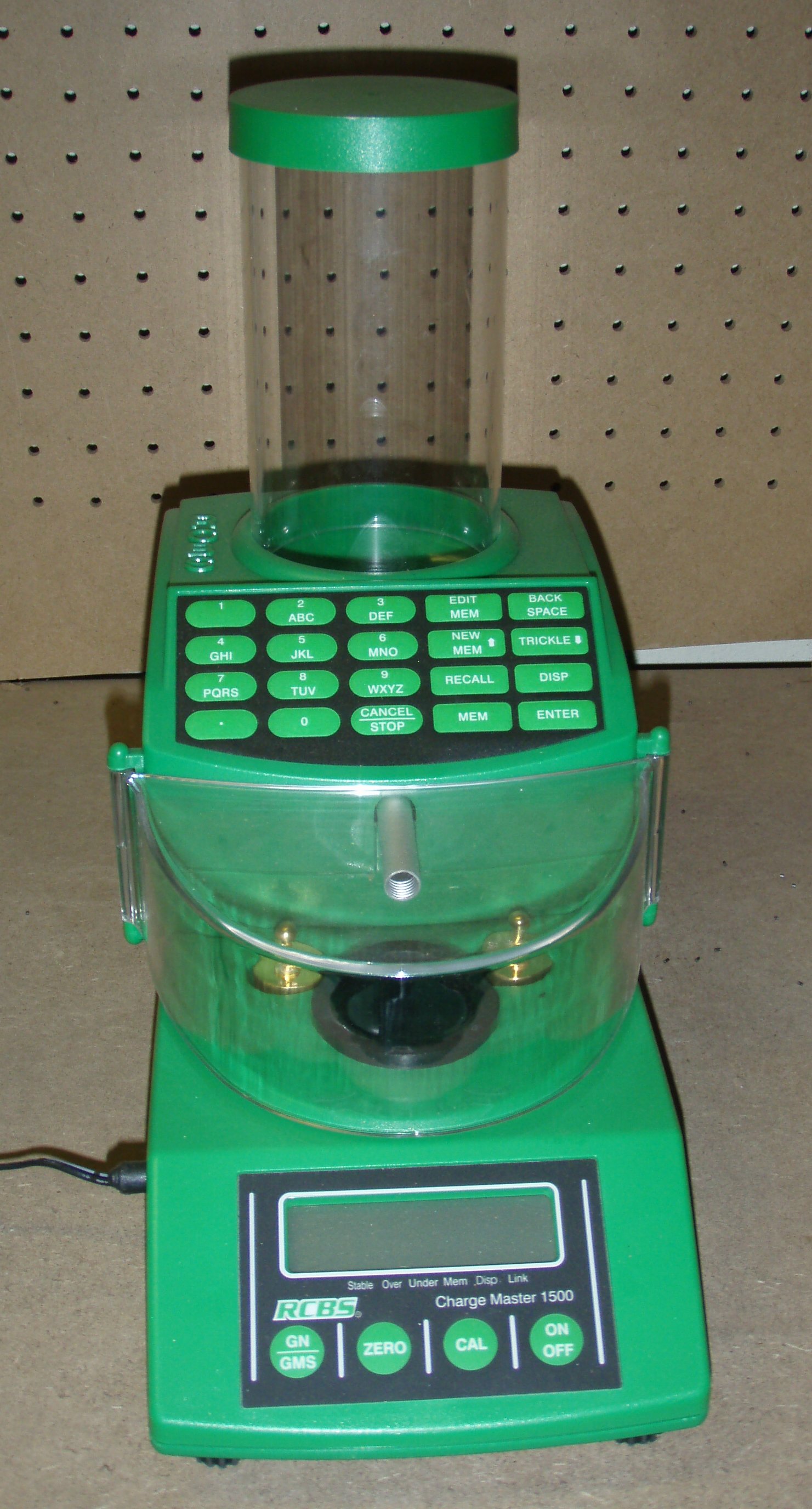 Figure 6 — An RCBS electronic powder dispenser, showing the hopper, the dispensing tube and the pan. The archetype of the consumer dispenser class. Photograph by Arthurrh, Public domain, via Wikimedia Commons…