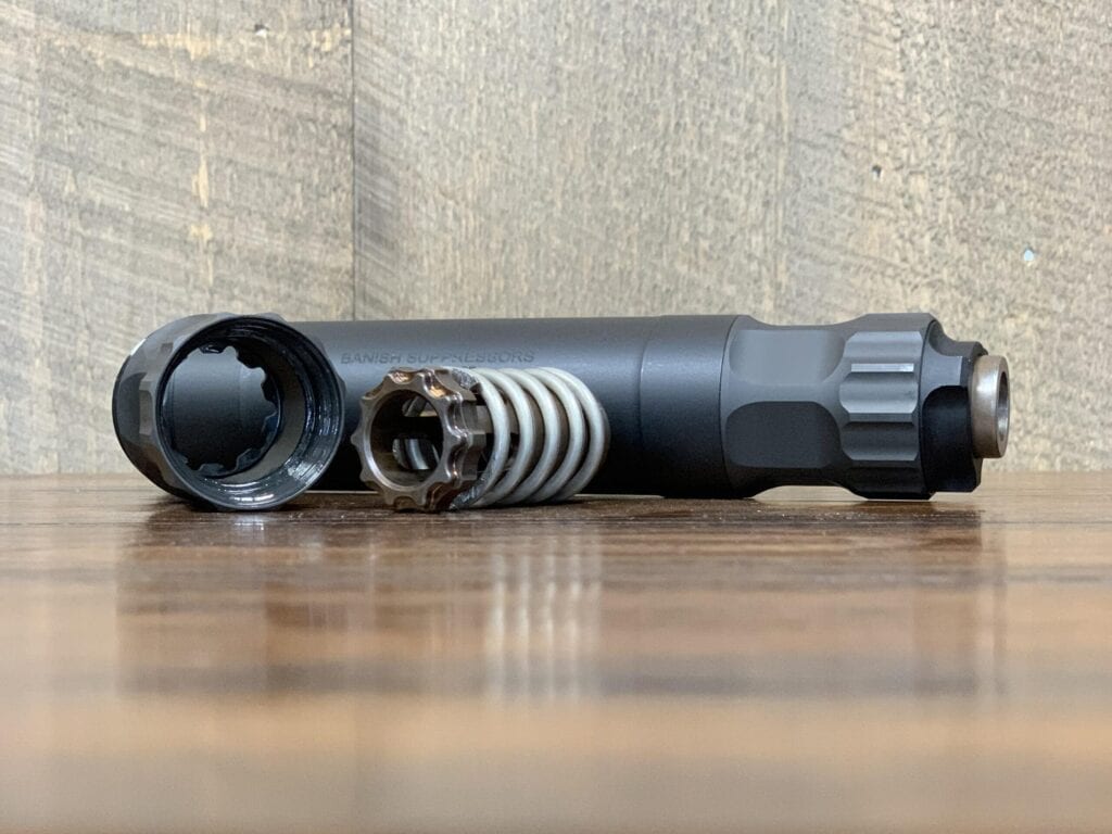 Figure 5 — The rear of a pistol suppressor with the booster assembly visible: the piston that threads to the barrel, and the spring that lets the can stay put while the barrel unlocks. Source: web, reference …
