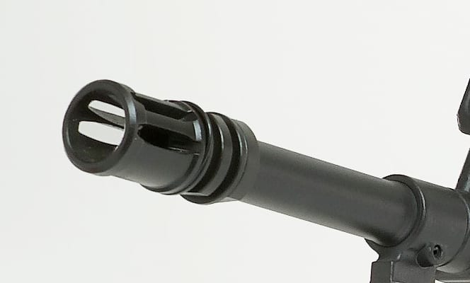 Figure 3 — A hybrid flash hider and compensator. A mount like this is a wear item: carbon on the seating surfaces eventually stops a can seating fully, which changes its alignment. Source: commons.wikimedia.o…